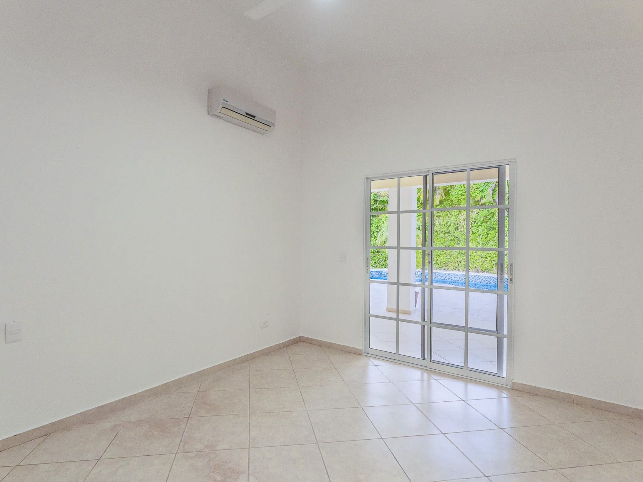 buyDRproperty Bright, empty room in a Renovated Villa CAOBA with sliding glass doors to a lush green view. Sosua Real Estate