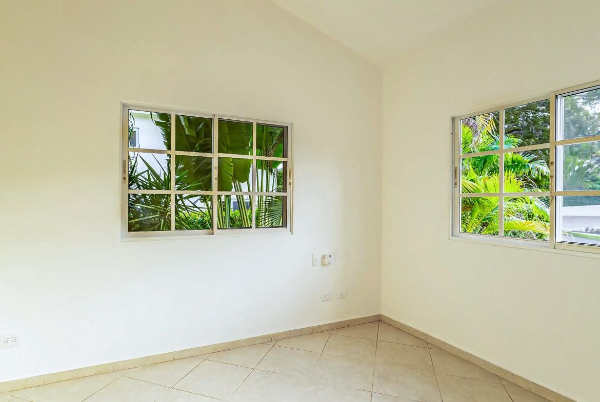 buyDRproperty Empty room with windows overlooking lush greenery. Renovated Villa CAOBA in Residencial Hispaniola. Sosua Real Estate