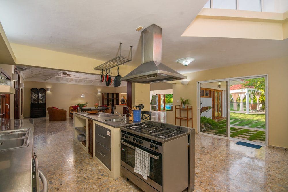 buyDRproperty Spacious kitchen with island and stainless steel appliances in a Villa LUNA oceanfront home. Sosua Real Estate