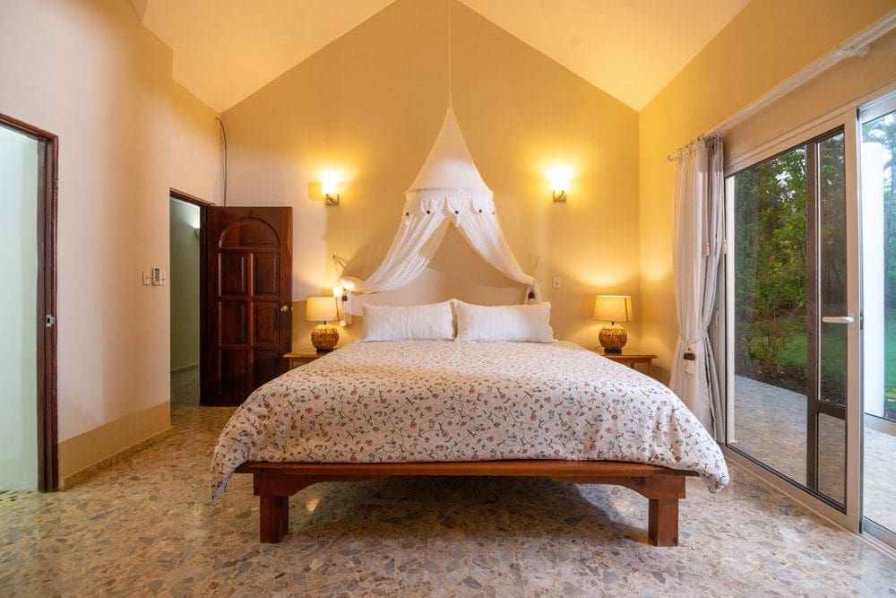 buyDRproperty Bedroom in a villa at Sea Horse Ranch, featuring a canopy bed and floral bedding. Sosua Real Estate
