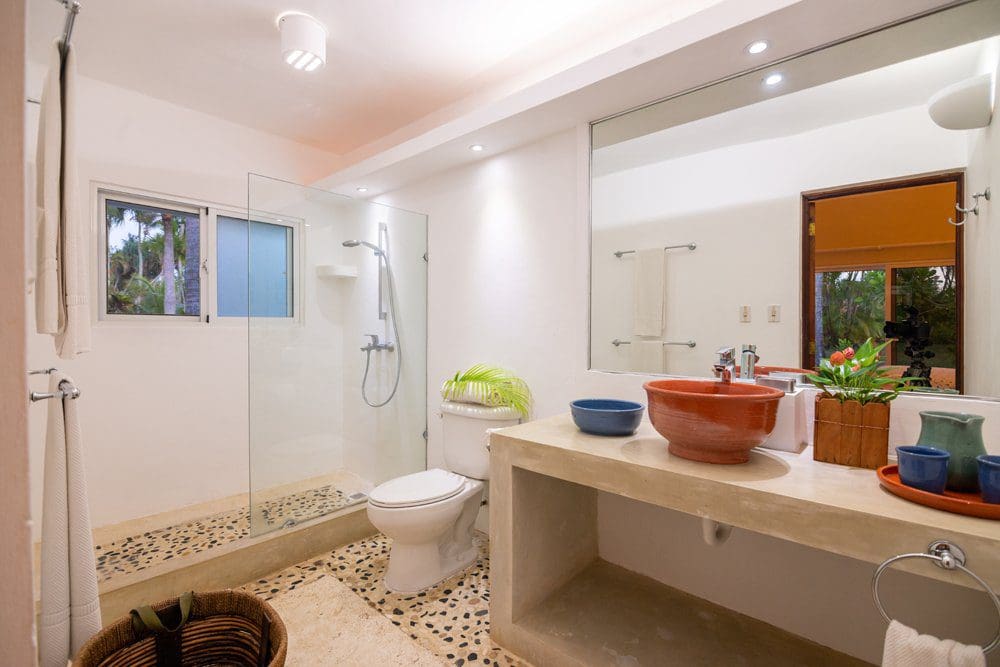 buyDRproperty Bathroom in Villa LUNA with stone shower floor, sink, and mirror. Sea Horse Ranch Sosua Real Estate