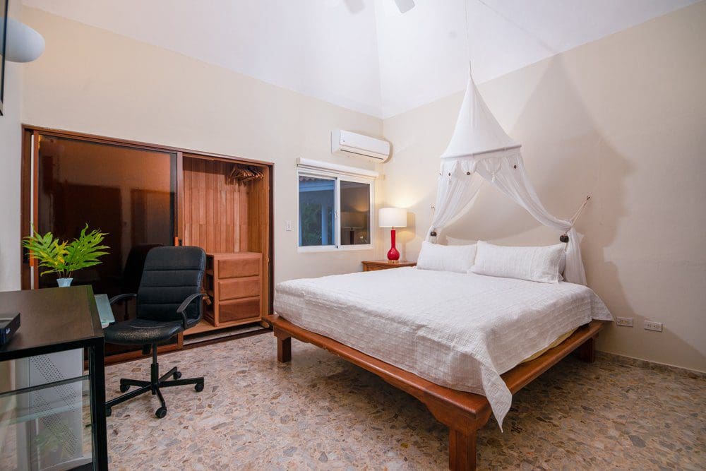 buyDRproperty Bedroom in a Villa Luna oceanfront property with canopy bed and desk Sosua Real Estate