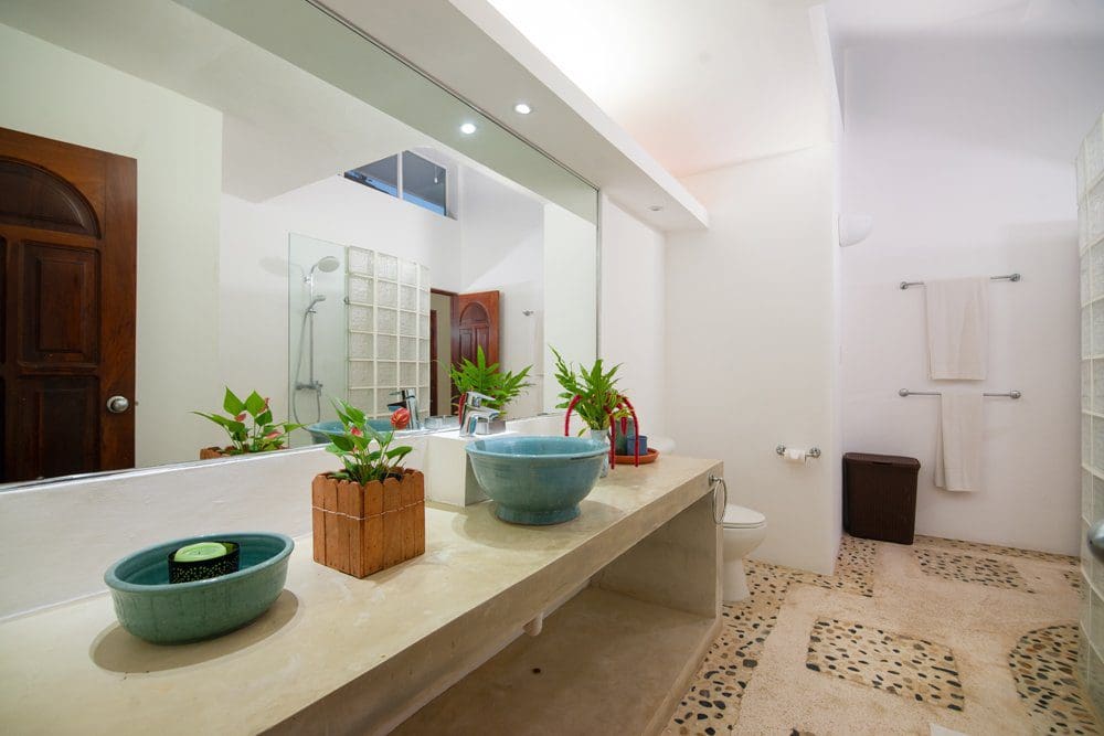 buyDRproperty Modern bathroom design in a Villa LUNA oceanfront property, featuring concrete countertop and blue sinks. Sosua Real Estate