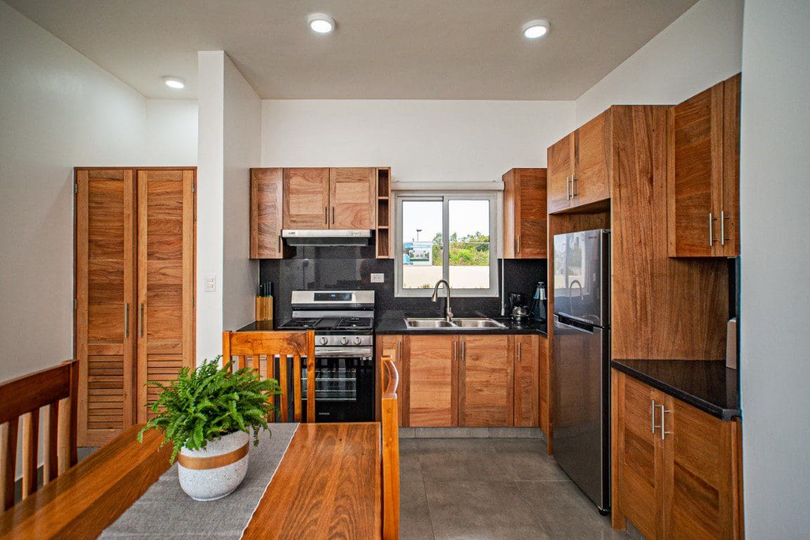 buyDRproperty Wooden kitchen in a Countryside Villa For Sale with black countertops and a dining area. Sosua Real Estate
