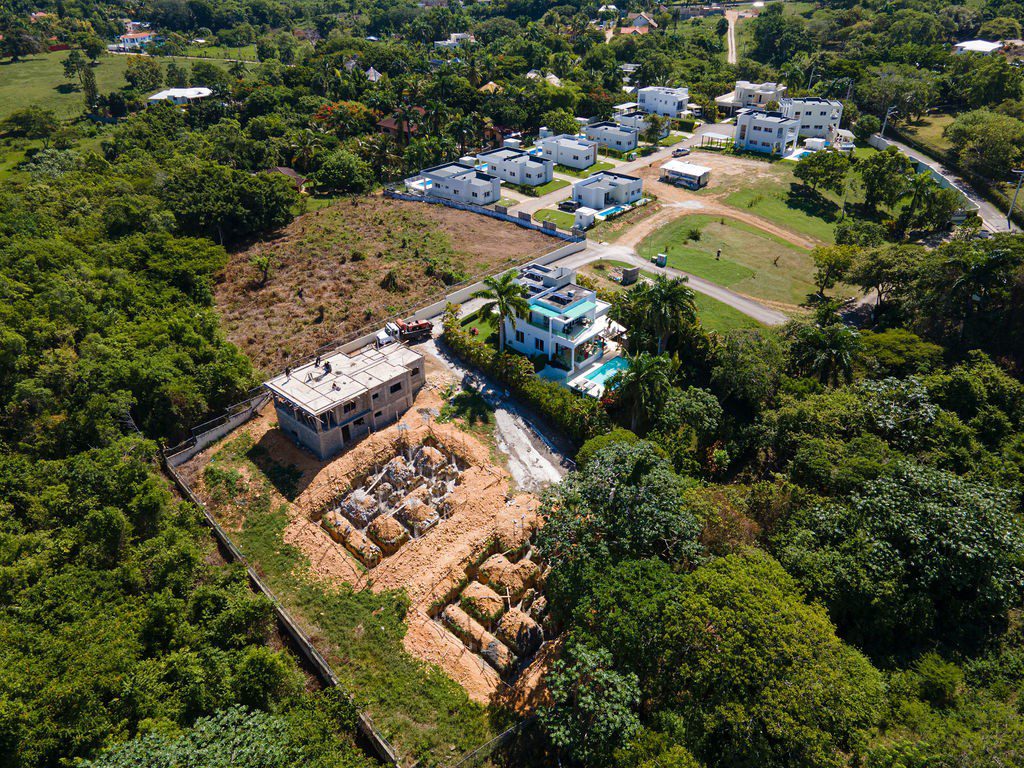 buyDRproperty Aerial view of a 3-Bedroom Oasis under construction, showcasing a future private pool villa in Sosua. Sosua Real Estate