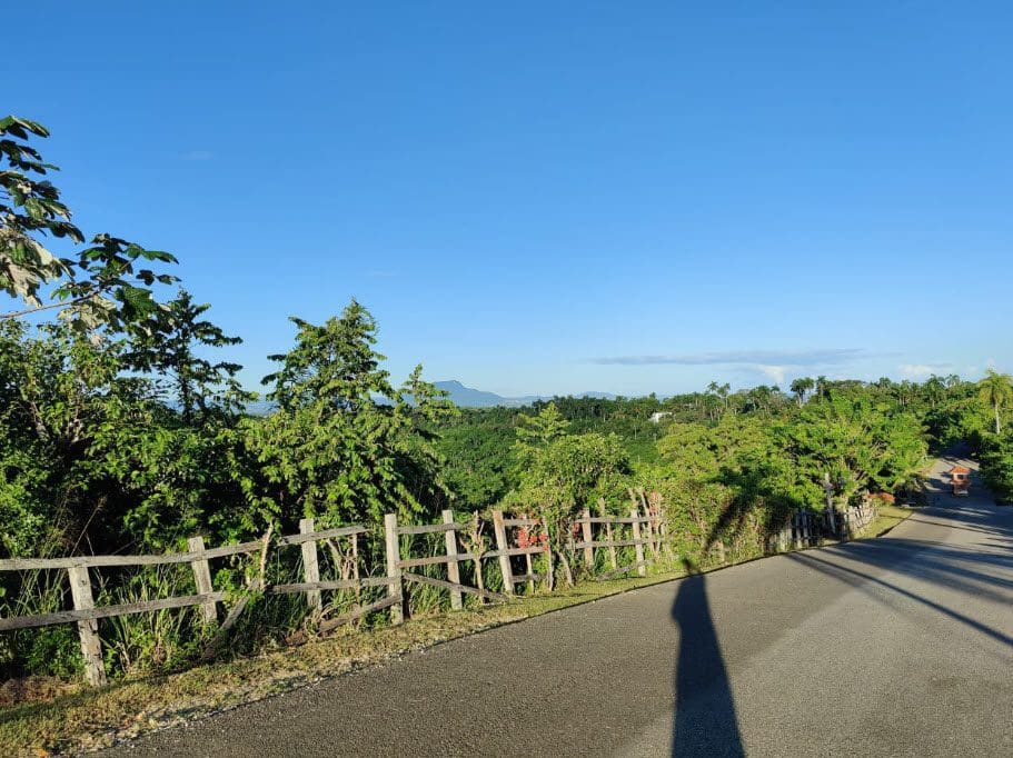 buyDRproperty Scenic view of Panorama Village with lush greenery and a road, beautiful building lots for sale. Sosua Real Estate