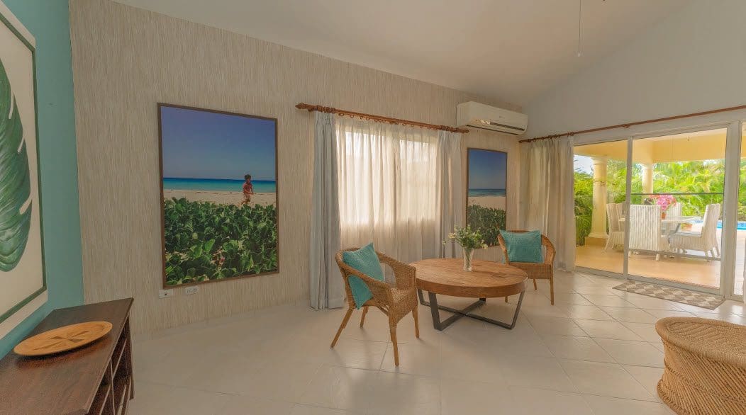 buyDRproperty Living room in a beautiful 3 bedroom villa with beach art and wicker furniture. Sosua Real Estate