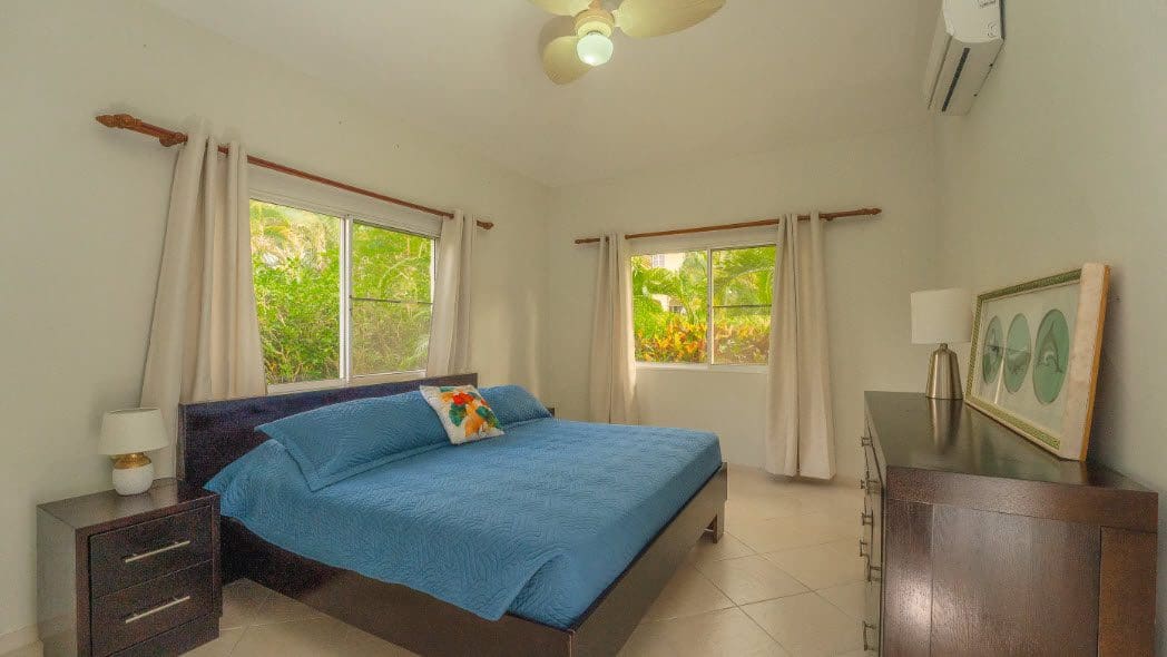 buyDRproperty Bedroom of a beautiful 3 bedroom villa with blue bedding and garden view Sosua Real Estate