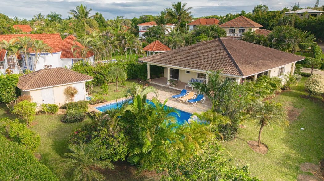 buyDRproperty Aerial view of a beautiful 3 bedroom villa with a pool and lush landscaping. Sosua Real Estate