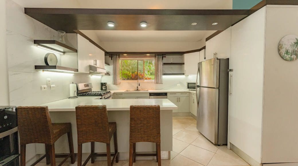 buyDRproperty Modern kitchen in a beautiful 3 bedroom villa with white cabinets and breakfast bar. Sosua Real Estate