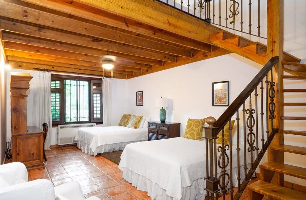 buyDRproperty Luxury bedroom in a stunning oceanfront villa with wooden beams and staircase. Sosua Real Estate
