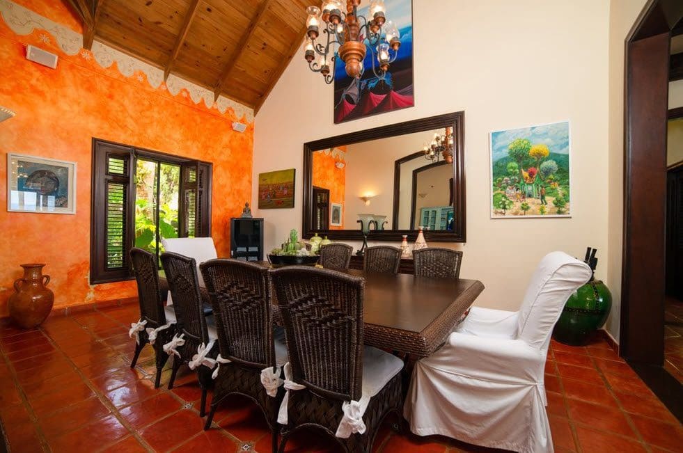 buyDRproperty Elegant dining room in a Stunning Oceanfront Villa, featuring a large mirror and chandelier. Sosua Real Estate