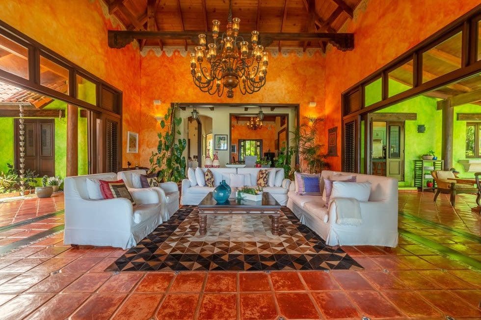 buyDRproperty Stunning oceanfront villa living room with vibrant orange and green walls, Sea Horse Ranch. Sosua Real Estate
