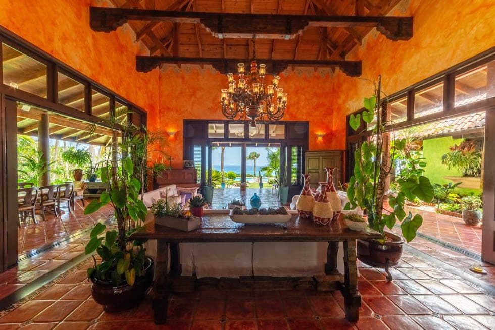 buyDRproperty Stunning oceanfront villa interior with a view of the sea. Features a chandelier, open doors, and Sea Horse Ranch. Sosua Real Estate