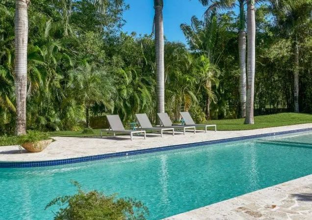 buyDRproperty Poolside view of the Beautiful Villa WINDWARD in Sea Horse Ranch with lounge chairs. Sosua Real Estate