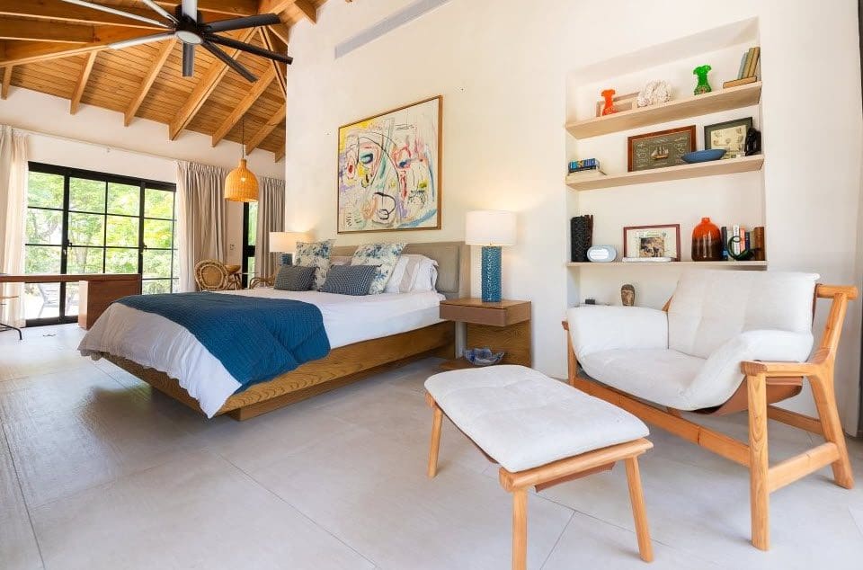 buyDRproperty Stunning villa bedroom interior with a large bed, chair, and shelves, part of the Stunning Villa SUNSET property. Sosua Real Estate