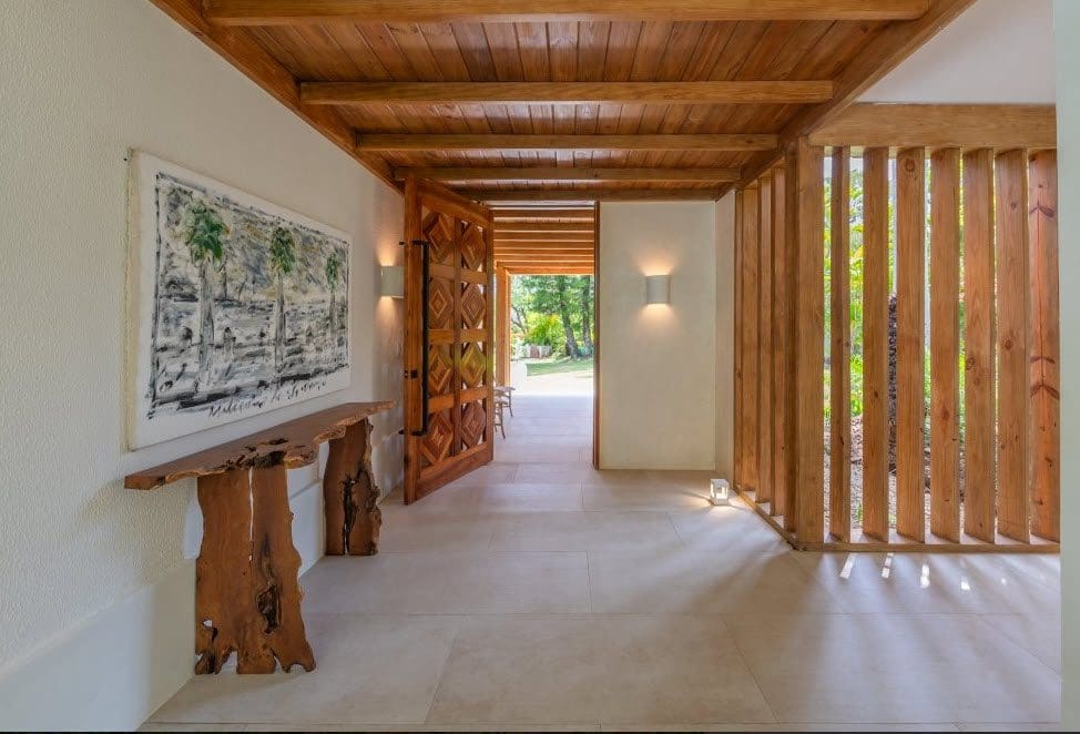 buyDRproperty Elegant villa entryway with wooden door and natural wood accents. Stunning Villa SUNSET for sale. Sosua Real Estate