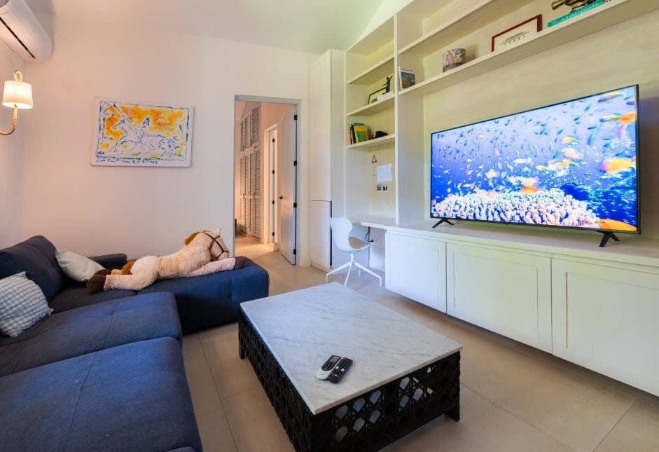 buyDRproperty Modern living room in Stunning Villa SUNSET with a large TV and a plush horse. Sosua Real Estate