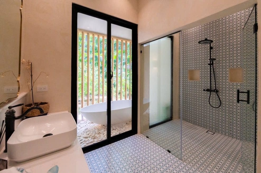 buyDRproperty Modern bathroom with patterned tile and a view of a bathtub outside the Stunning Villa SUNSET. Sosua Real Estate