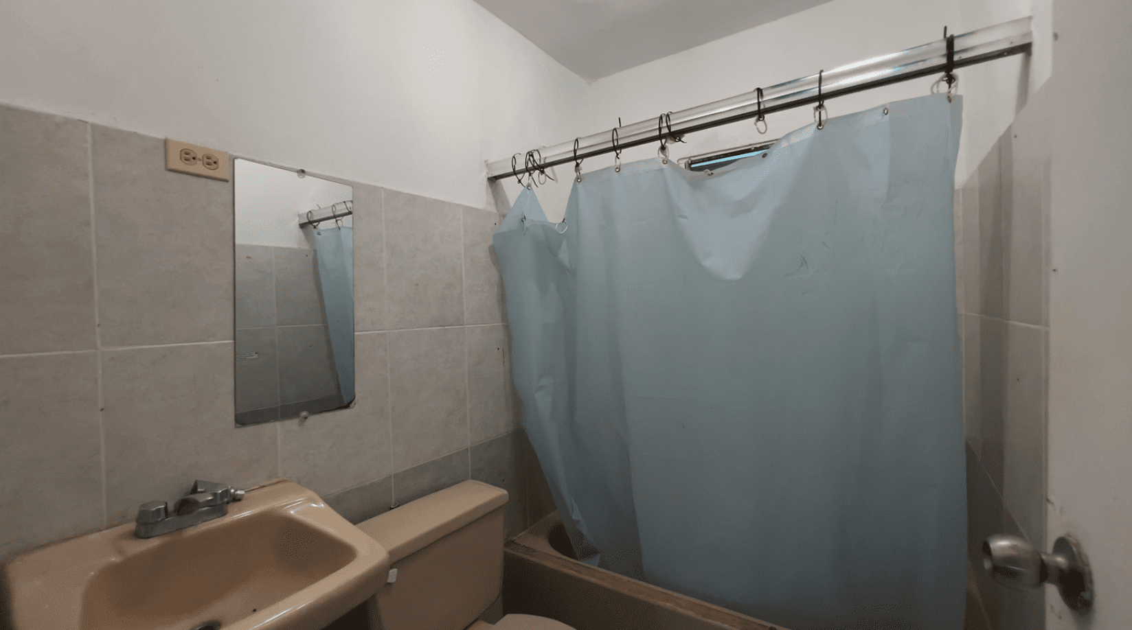 buyDRproperty Bathroom with a shower curtain, sink, and mirror in a hostel business. Sosua Real Estate