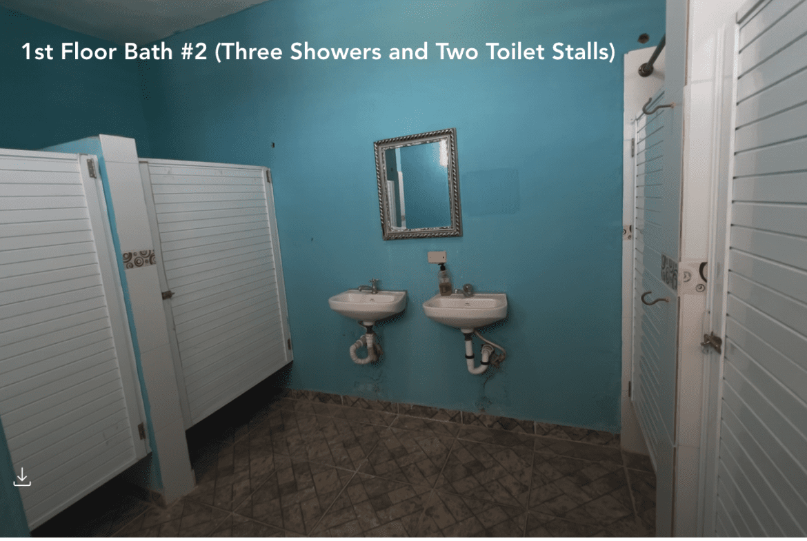 buyDRproperty Public bathroom with three stalls and two sinks, possibly part of a Hostel Business. Sosua Real Estate