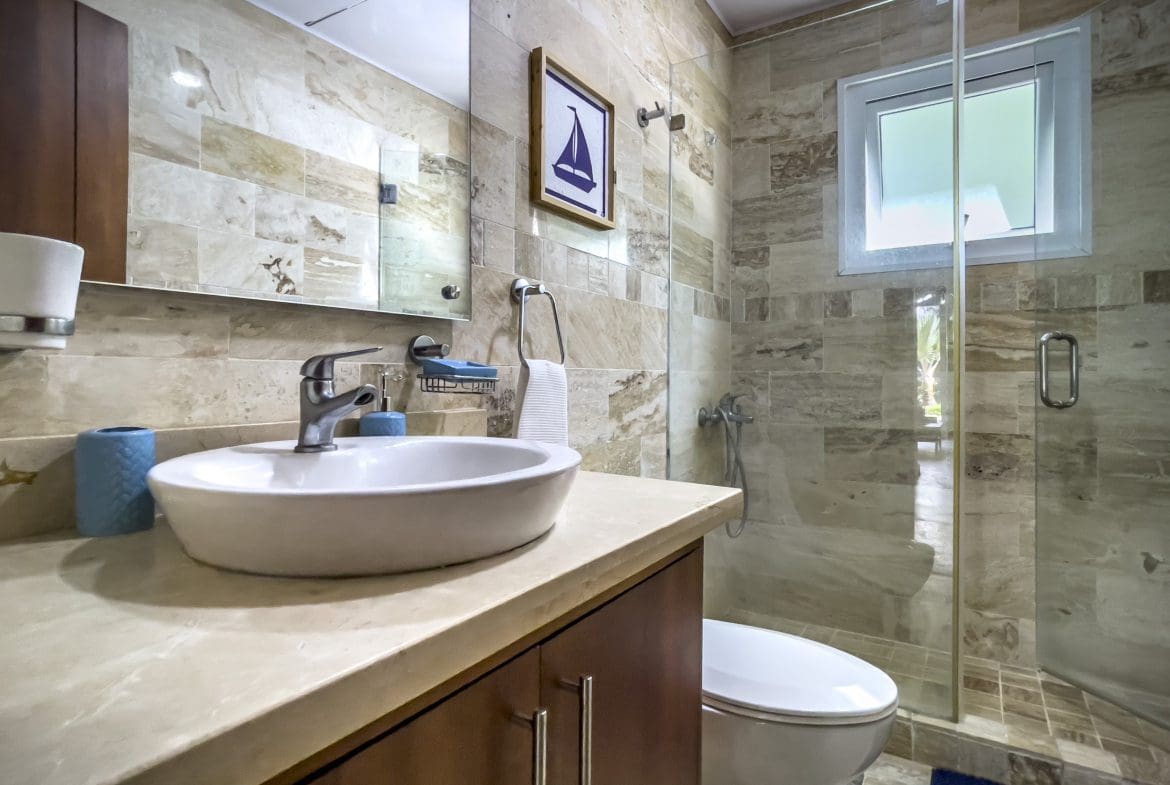 buyDRproperty Bathroom of a 3 Bedroom Oceanfront Condo with a glass shower and neutral tile. Sosua Real Estate