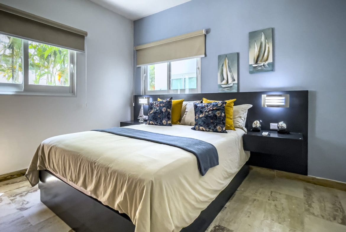 buyDRproperty Cozy bedroom in a 3 bedroom oceanfront condo, featuring a king-size bed and modern decor. Sosua Real Estate