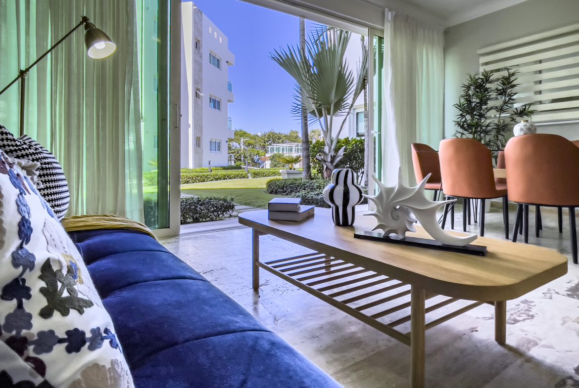 buyDRproperty Living room of a 3 bedroom oceanfront condo with a view of the buildings and the garden. Sosua Real Estate