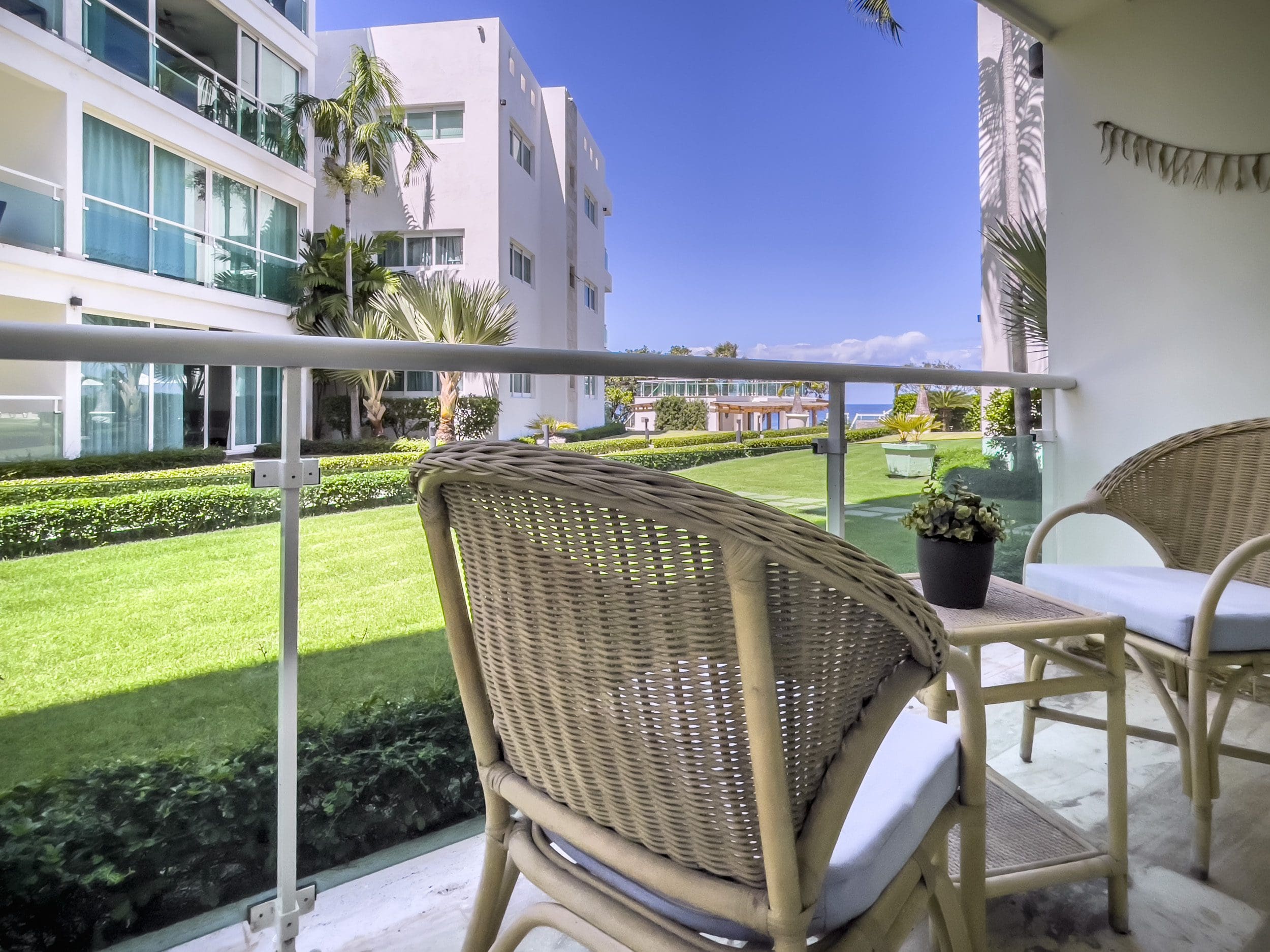 buyDRproperty Balcony view of a 3 Bedroom Oceanfront Condo with wicker furniture and ocean views. Sosua Real Estate