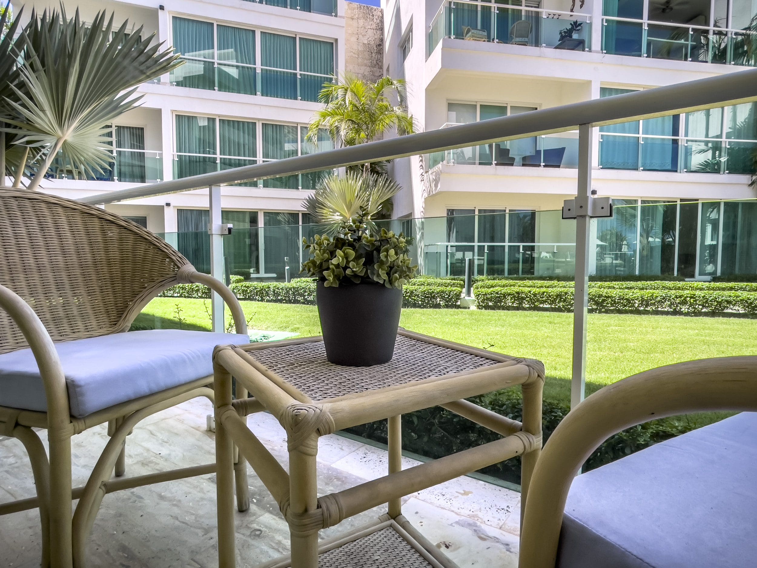 buyDRproperty Balcony with wicker furniture overlooking a 3 Bedroom Oceanfront Condo's lawn. Sosua Real Estate