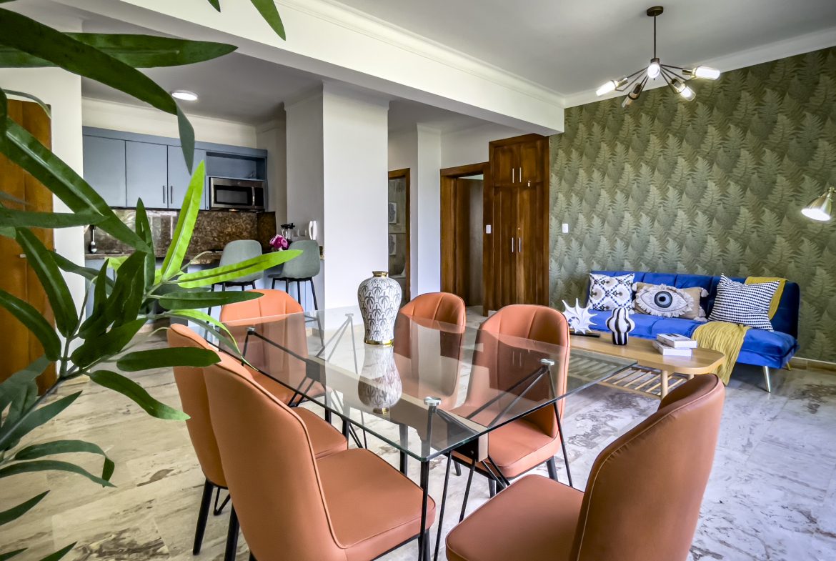 buyDRproperty Modern dining area in a 3 bedroom oceanfront condo with glass table and orange chairs Sosua Real Estate
