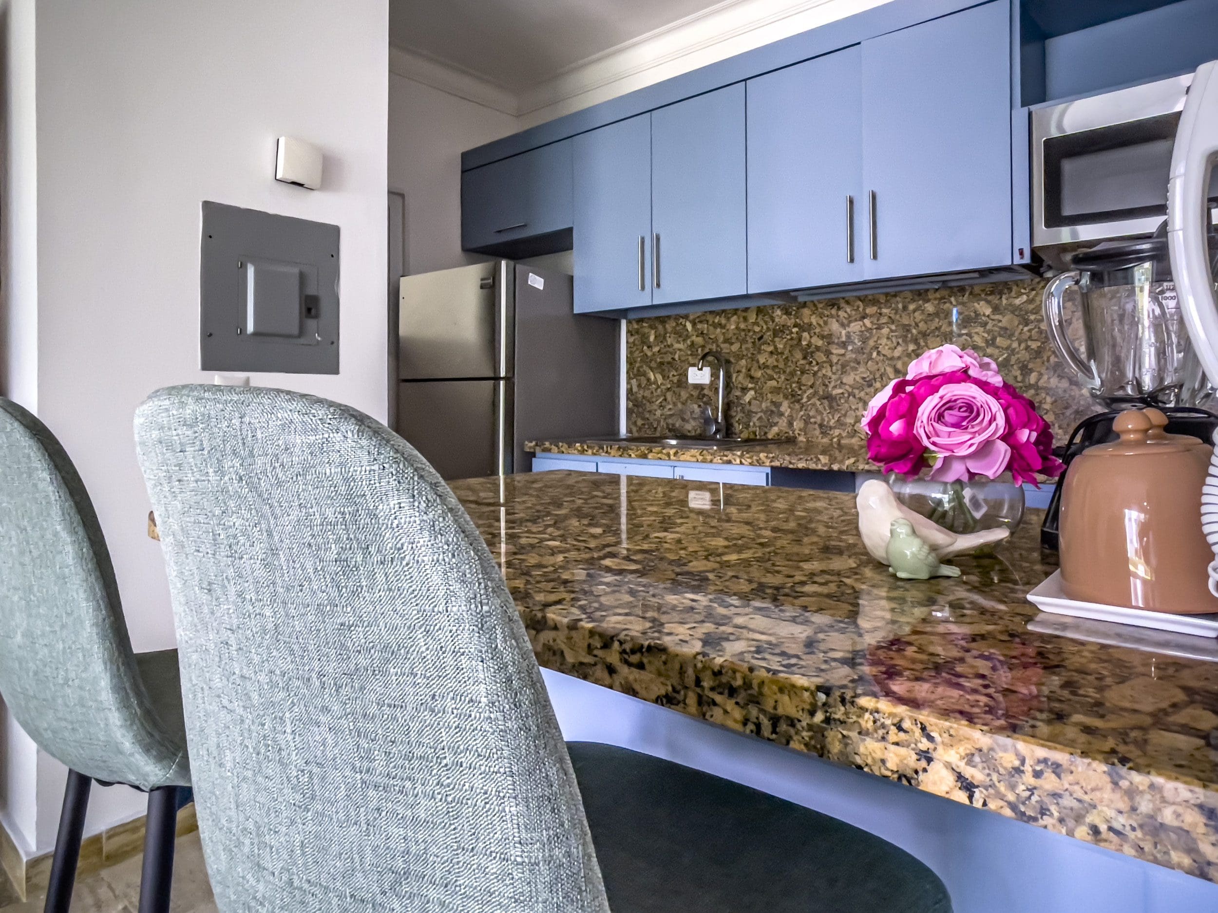 buyDRproperty Modern kitchen with blue cabinets and granite countertop in a 3 Bedroom Oceanfront Condo. Sosua Real Estate