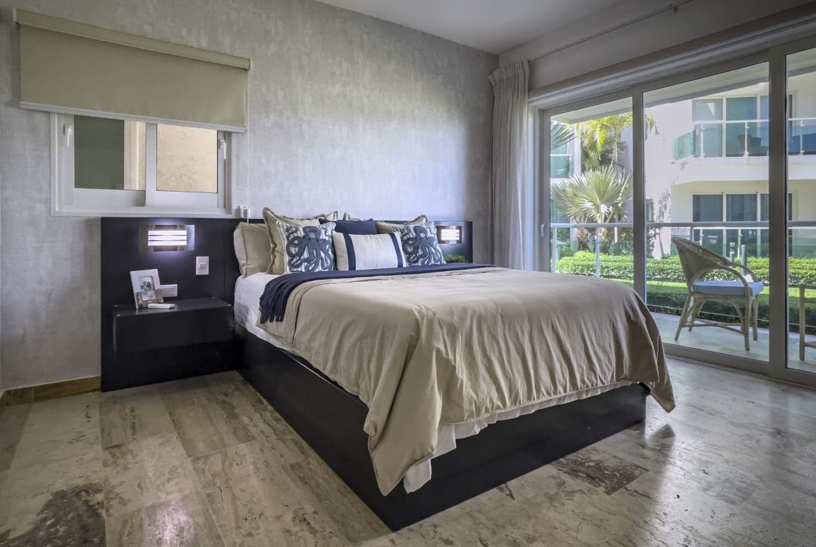 buyDRproperty Bedroom in a 3 Bedroom Oceanfront Condo for sale with large bed and balcony view. Sosua Real Estate