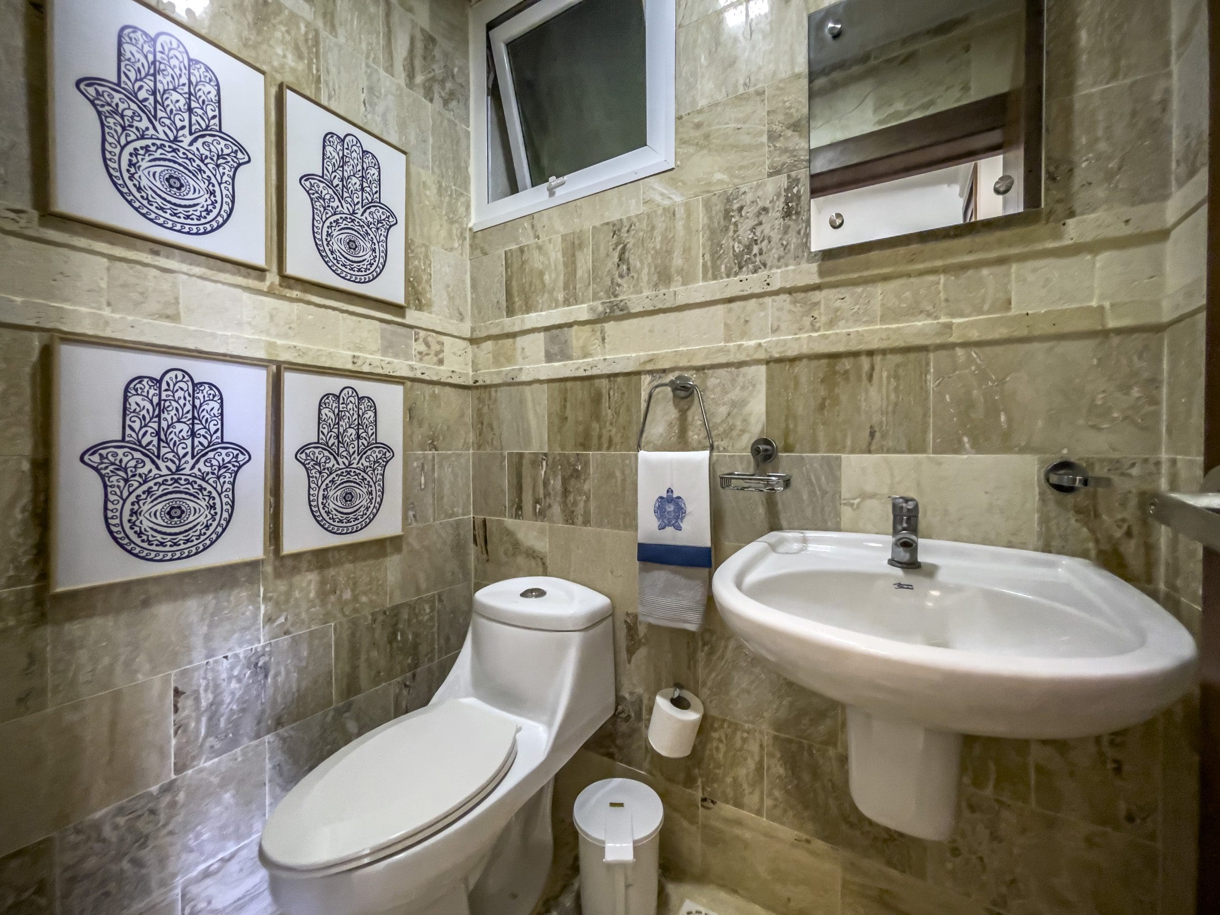 buyDRproperty Bathroom in a 3 Bedroom Oceanfront Condo with Hamsa hand art. Sosua Real Estate