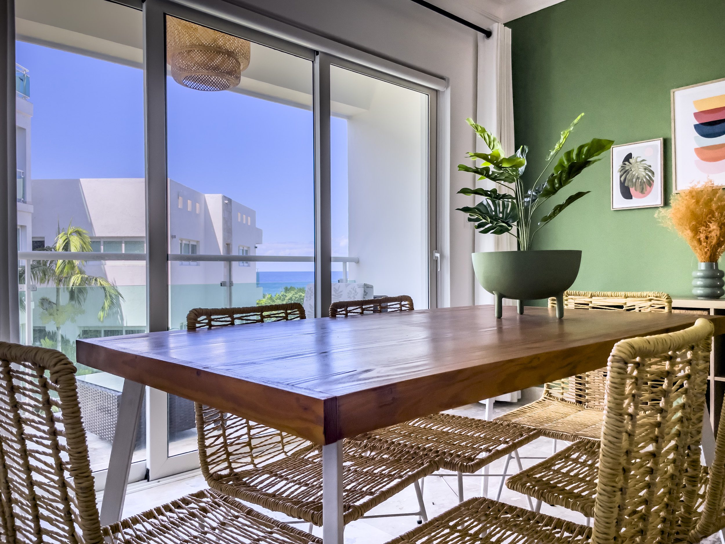 buyDRproperty Oceanfront condo for sale: Dining room with ocean view and woven chairs. Sosua Real Estate