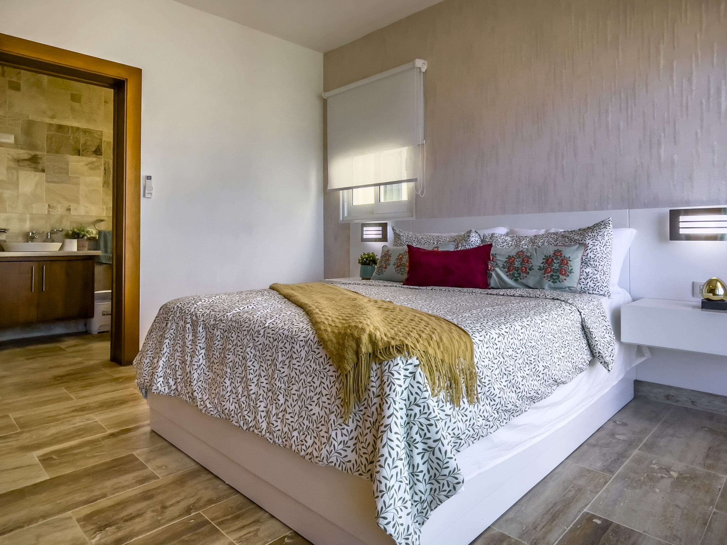 buyDRproperty Modern bedroom with bed, nightstand, and decorative pillows. Oceanfront Condo For Sale. Sosua Real Estate