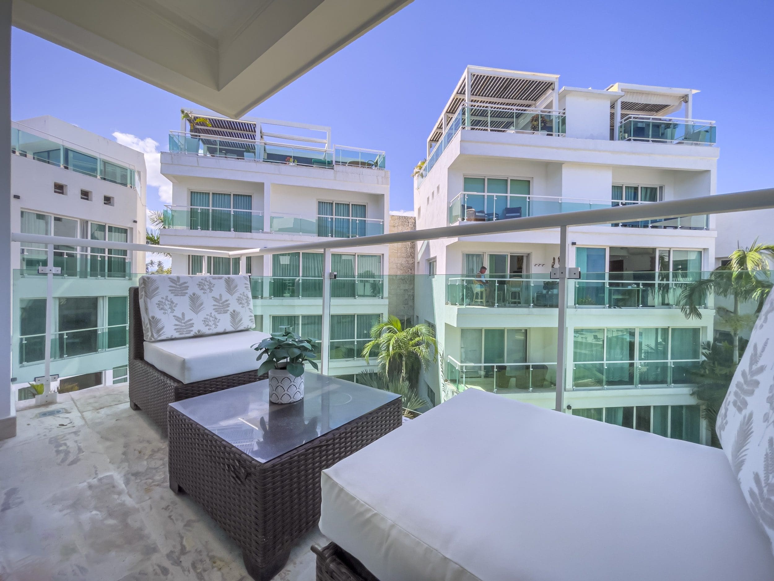 buyDRproperty Balcony of an oceanfront condo for sale with outdoor furniture and a view of other condos. Sosua Real Estate