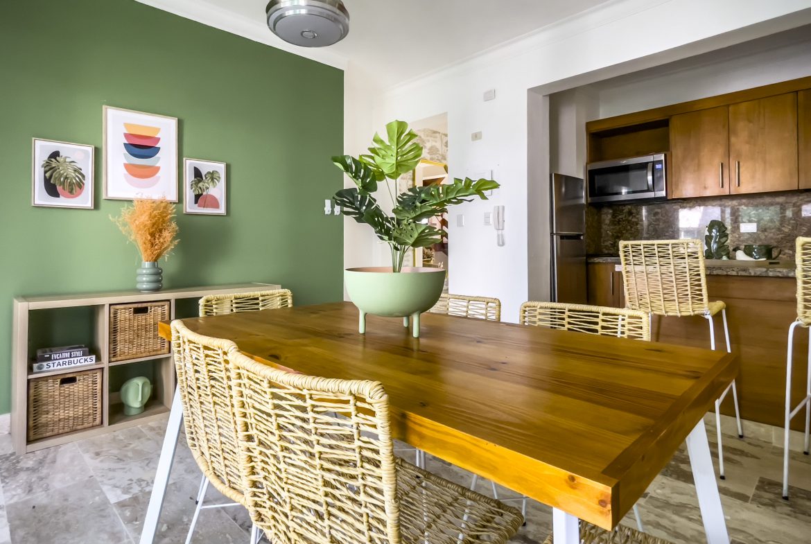 buyDRproperty Modern dining room with wooden table and woven chairs in an oceanfront condo for sale. Sosua Real Estate