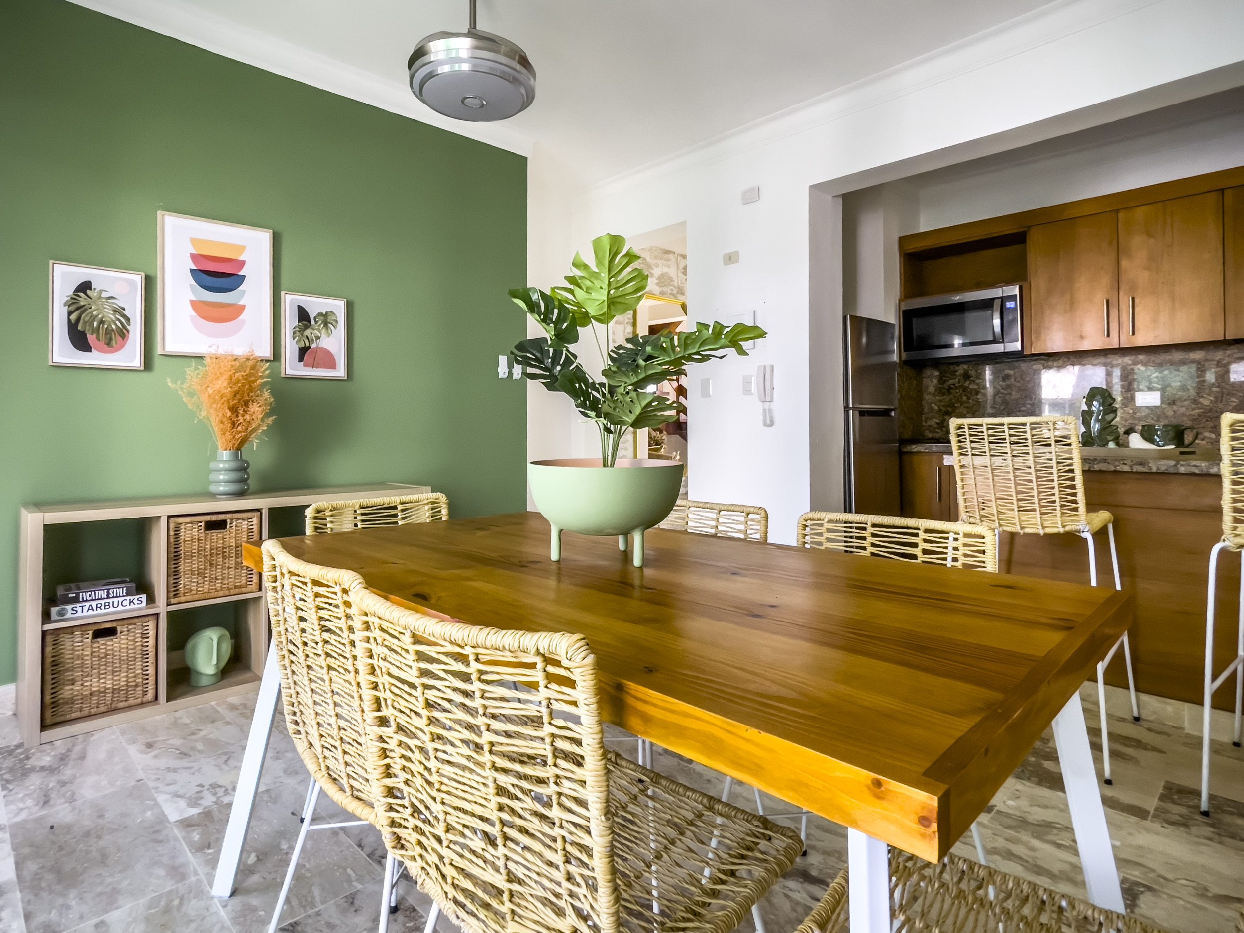 buyDRproperty Modern dining room with wooden table and woven chairs in an oceanfront condo for sale. Sosua Real Estate