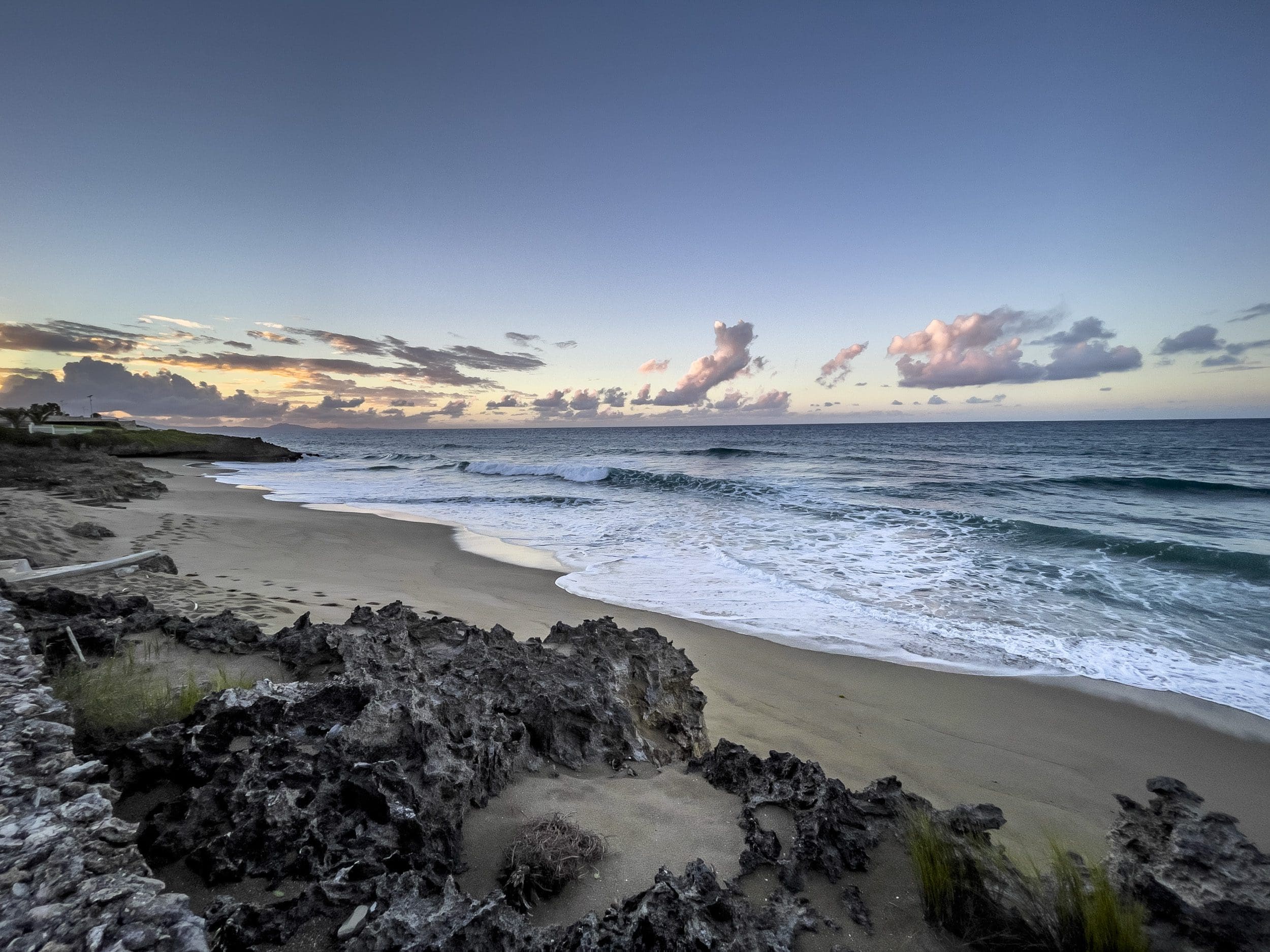 buyDRproperty Ocean view from a 3 Bedroom Oceanfront Condo with beach, waves, and rocks at sunset. Sosua Real Estate