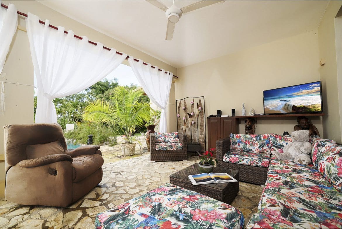 buyDRproperty Living room with a view in a Beautiful 4 Bedroom Villa in Sosua. Featuring a brown recliner and floral patterned sofa. Sosua Real Estate