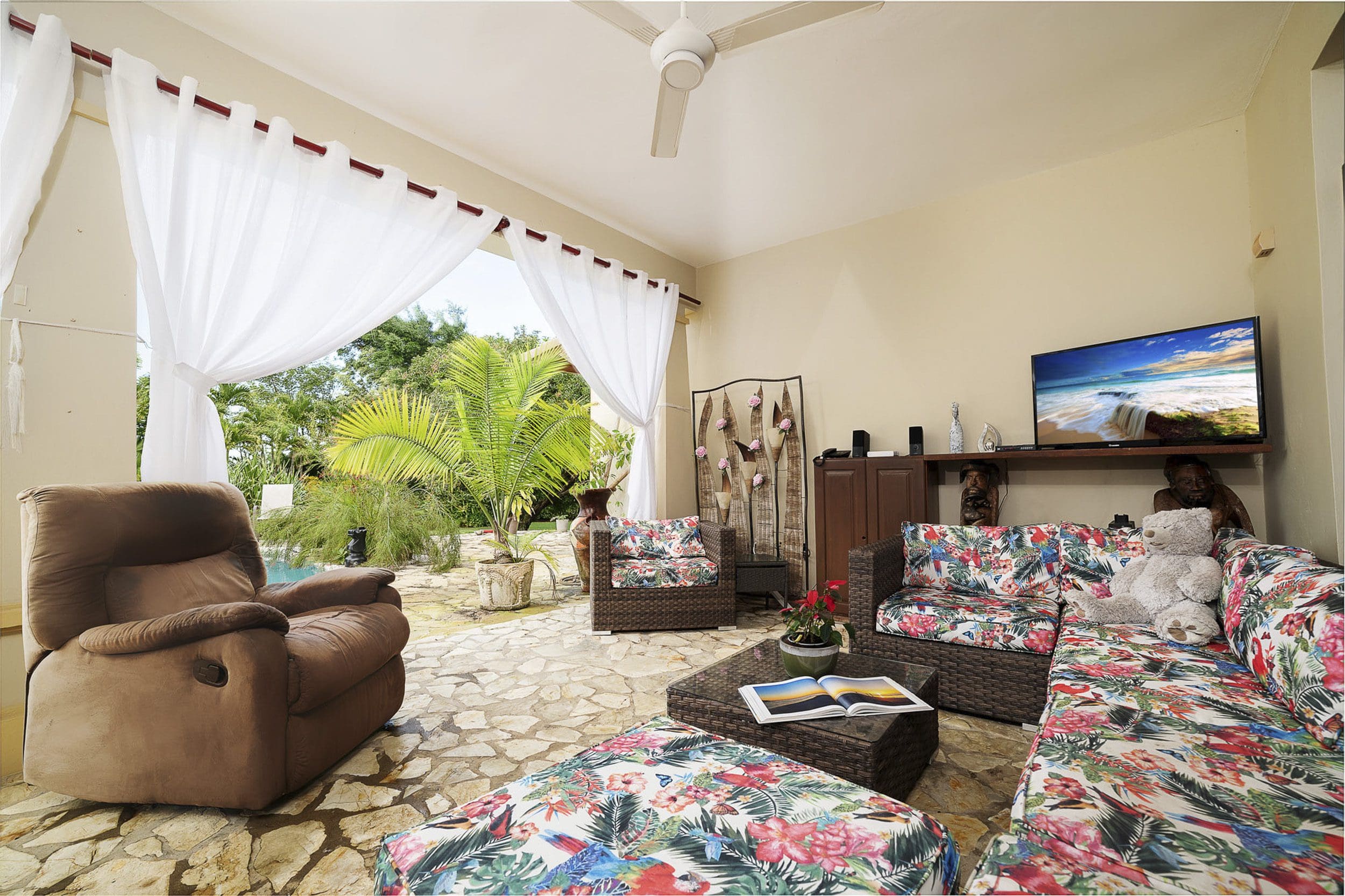 buyDRproperty Living room with a view in a Beautiful 4 Bedroom Villa in Sosua. Featuring a brown recliner and floral patterned sofa. Sosua Real Estate