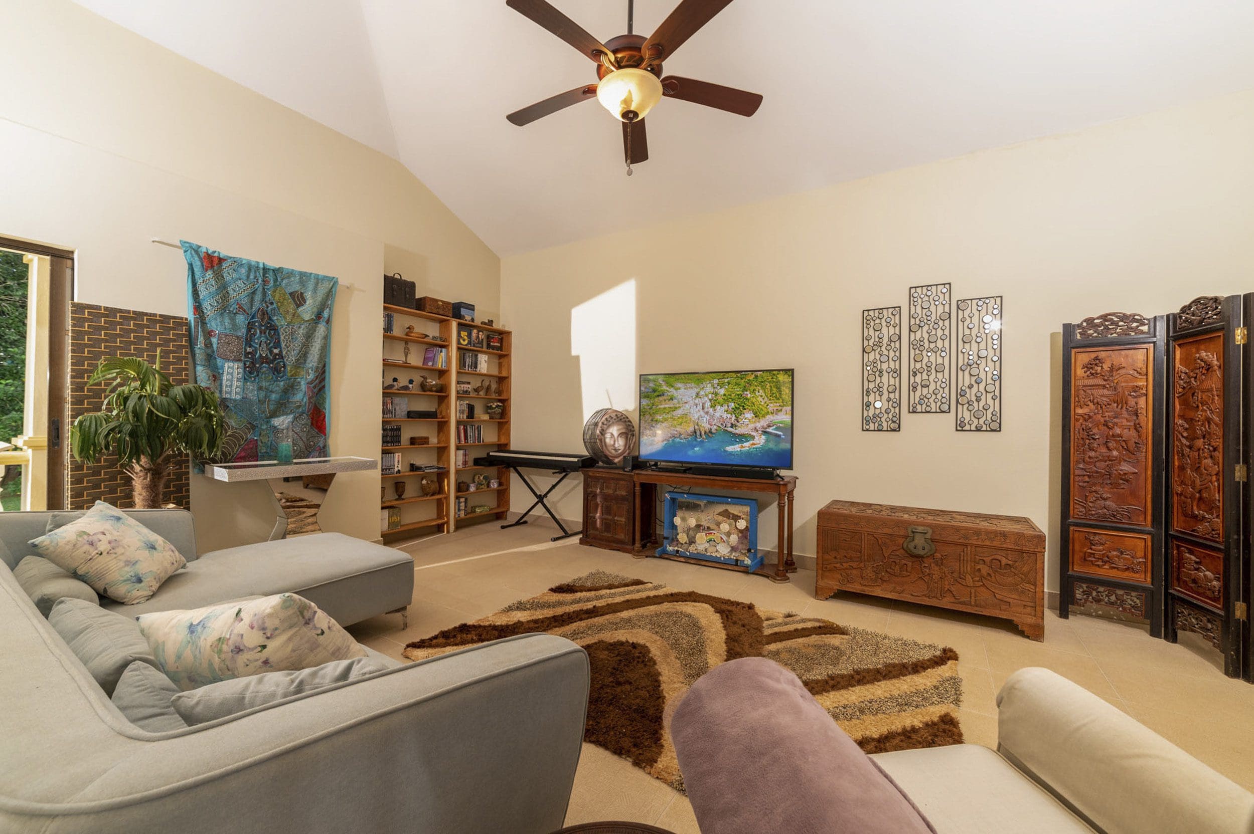 buyDRproperty Living room in a beautiful 4 bedroom villa for sale in Sosua. Features include a comfortable sofa, rug, and decorative elements. Sosua Real Estate