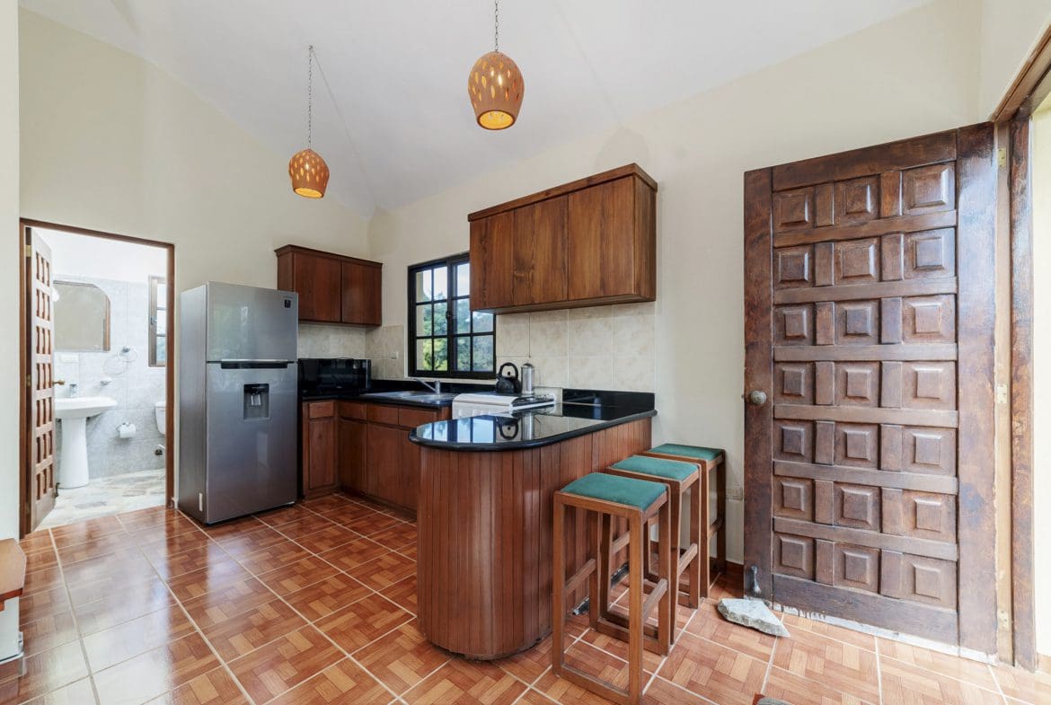 buyDRproperty Kitchen in a Beautiful 4 Bedroom Villa for sale in Sosua. Wooden cabinets, breakfast bar and open door. Sosua Real Estate