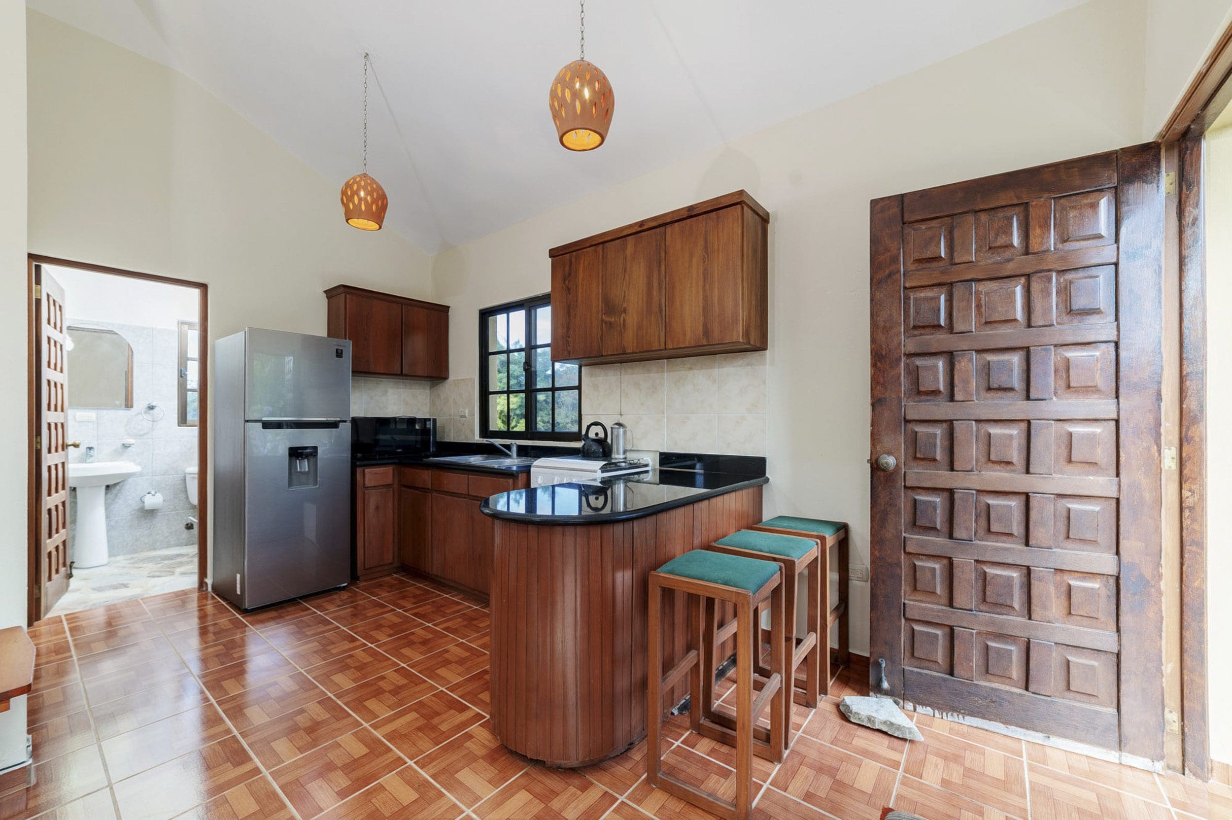 buyDRproperty Kitchen in a Beautiful 4 Bedroom Villa for sale in Sosua. Wooden cabinets, breakfast bar and open door. Sosua Real Estate