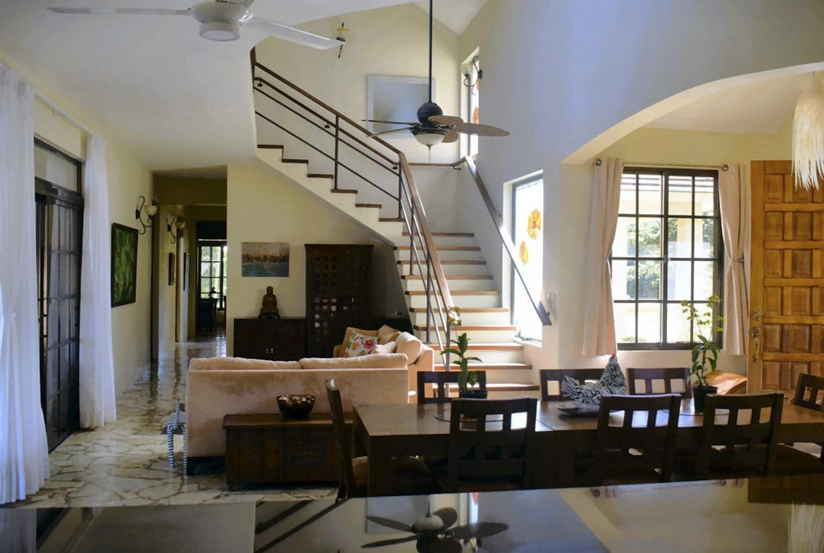buyDRproperty Spacious living area of a Beautiful 4 Bedroom Villa, featuring a staircase and dining table Sosua Real Estate