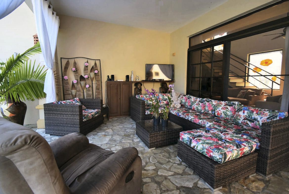 buyDRproperty Outdoor living space with wicker furniture, colorful cushions, and a stone floor in a Beautiful 4 Bedroom Villa. Sosua Real Estate
