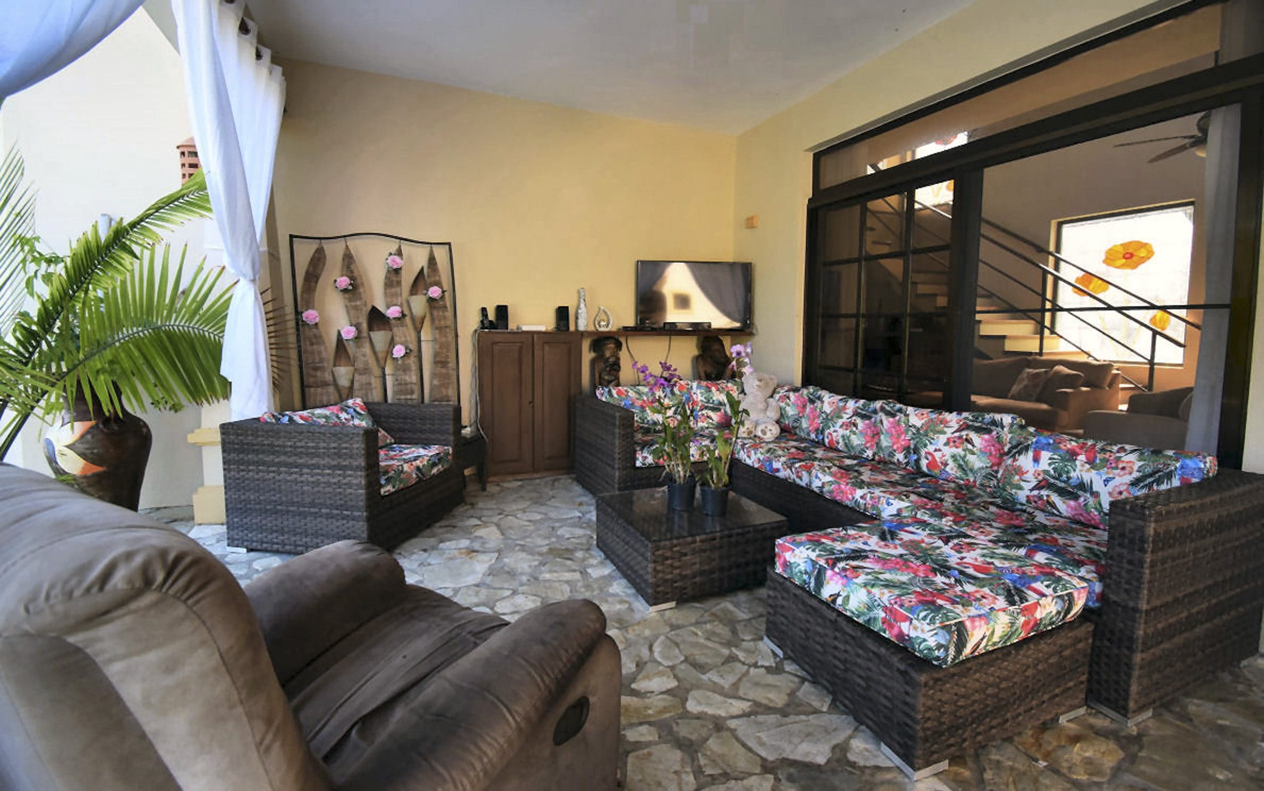 buyDRproperty Outdoor living space with wicker furniture, colorful cushions, and a stone floor in a Beautiful 4 Bedroom Villa. Sosua Real Estate