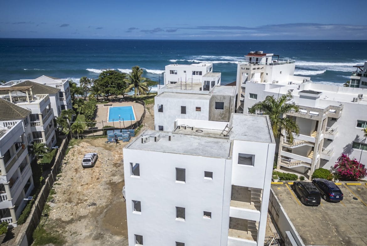 buyDRproperty Aerial view of an oceanfront condo in Sosua with a pool and ocean view. Sosua Real Estate