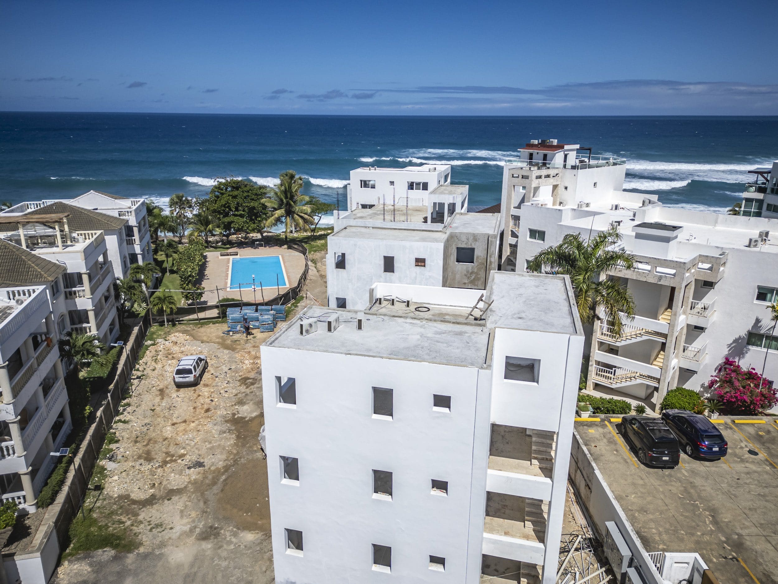 buyDRproperty Aerial view of an oceanfront condo in Sosua with a pool and ocean view. Sosua Real Estate